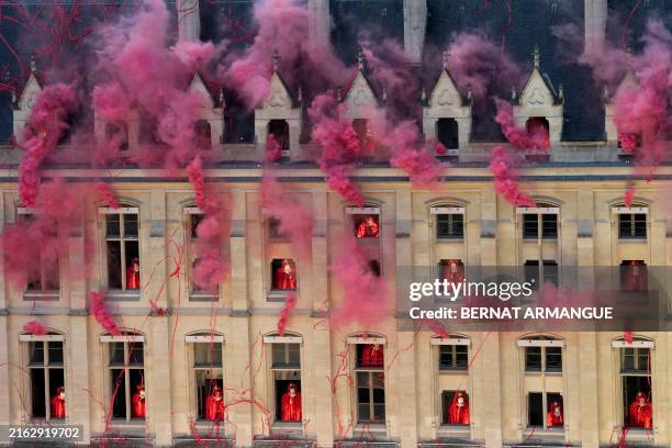 Smoke billows near windows as performers depicting the 18th century Queen Marie Antoinette participate and Metal band Gojira and opera singer Marina...