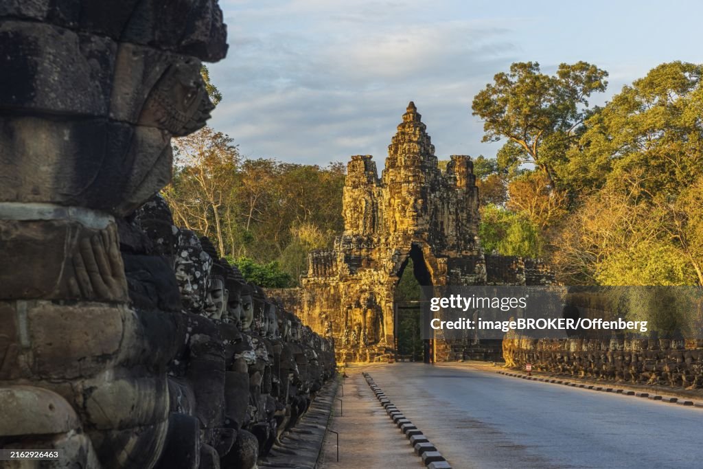Stone Gate of Angkor Thom in Cambodia illuminated by the setting sun