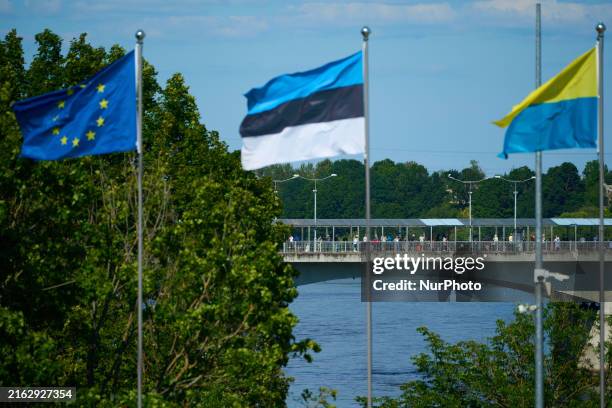 People are seen crossing the border with Russia with EU, Estonia and Ukraine flags flying in Narva, Estonia on 24 July, 2024. Estonian authorities...