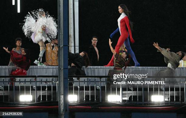 Model presents creations while walking a catwalk erected along the Passerelle Debilly bridge on the Seine river during the opening ceremony of the...