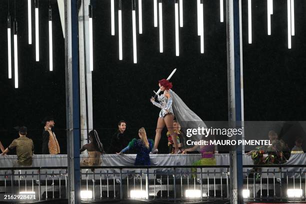 Model presents creations while walking a catwalk erected along the Passerelle Debilly bridge on the Seine river during the opening ceremony of the...