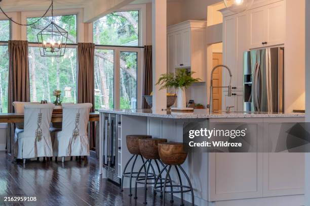 moderne offene landhausküche mit großer quarzinsel - flaschenpost stock-fotos und bilder