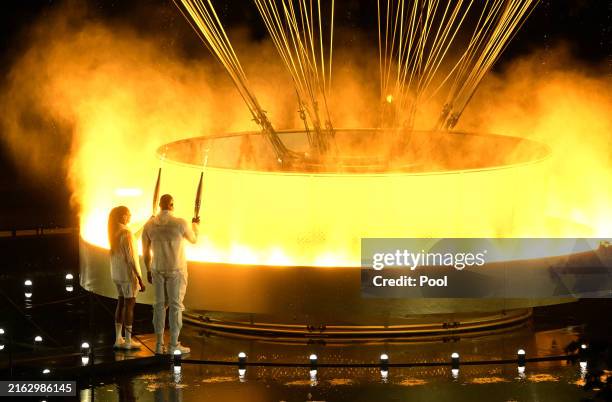Torchbearers Teddy Riner and Marie-Jose Perec light up the Olympic cauldron during the opening ceremony of the Paris 2024 Olympic Games in Paris,...