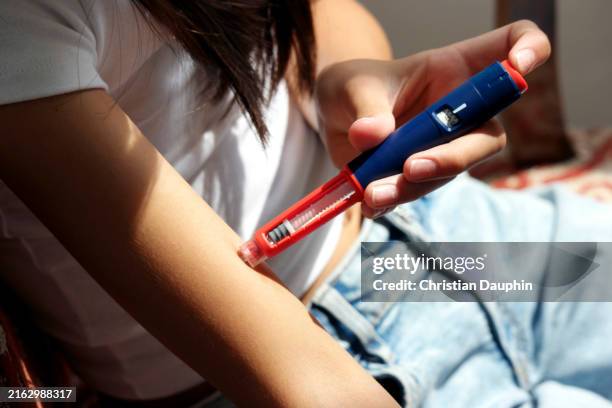 a mixed-race teenager injecting insulin with insulin pen. - compromised immune system stock pictures, royalty-free photos & images