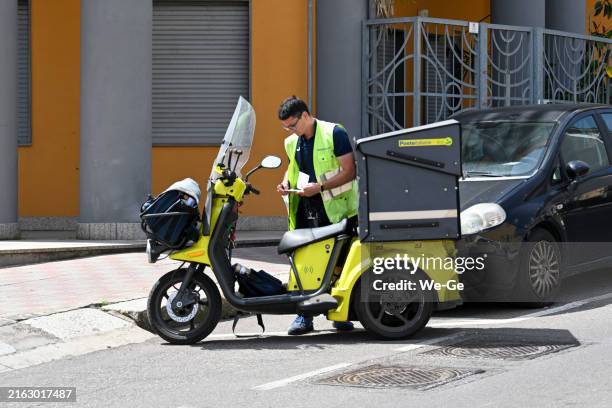 a poste italiane letter carrier on a motorcycle delivering mail in cagliari, sardinia. - postino foto e immagini stock