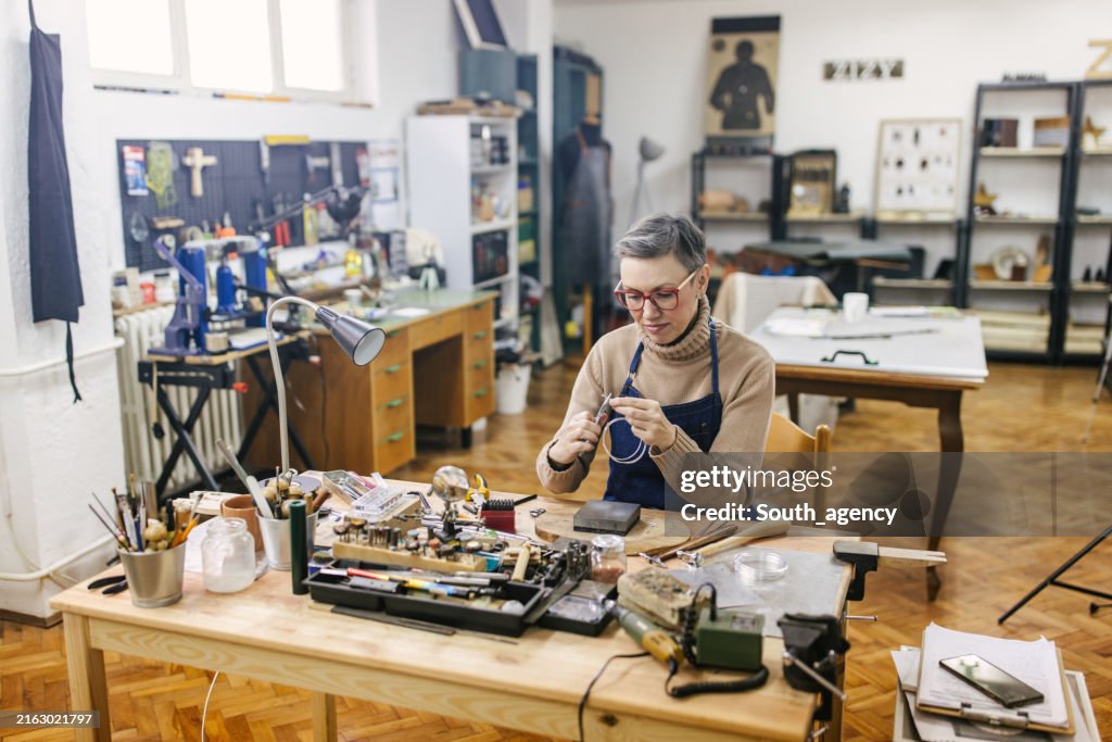 Jeweller diligently working in well-equipped studio