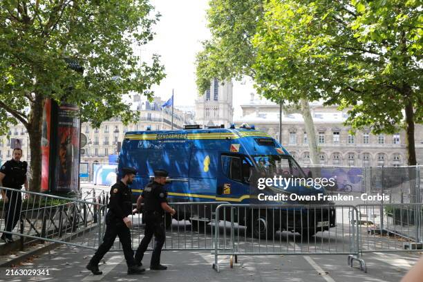 Few days before the beginning of the Paris Olympics, a Paris policeman move a metal barricade to block access to certain areas.