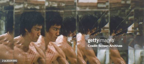 Bruce Lee bare-chested with scratch marks from his fight with Han in room of mirrors from the classic 1973 martial arts movie 'Enter The Dragon'.