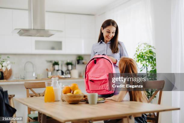 joven madre e hija empacando mochila para la escuela - back to school fotografías e imágenes de stock