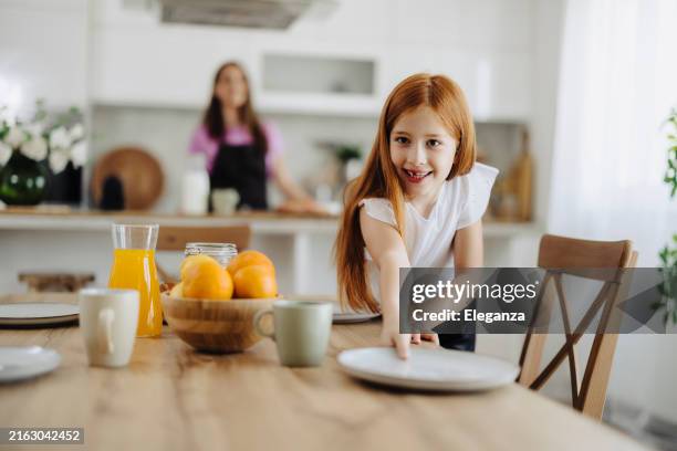 mom and daughter preparing breakfast and setting the table - setting the table stock pictures, royalty-free photos & images