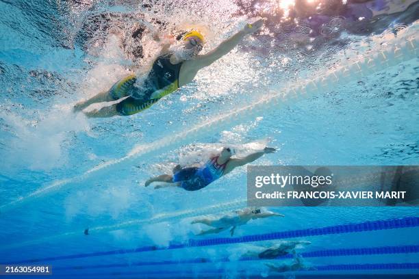 An underwater view shows Australia's Ariarne Titmus and US' Katie Ledecky as they compete in a heat of the women's 100m butterfly swimming event...