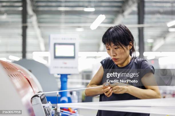 Worker is working at a production workshop of a textile company in Suqian, China, on July 27, 2024.
