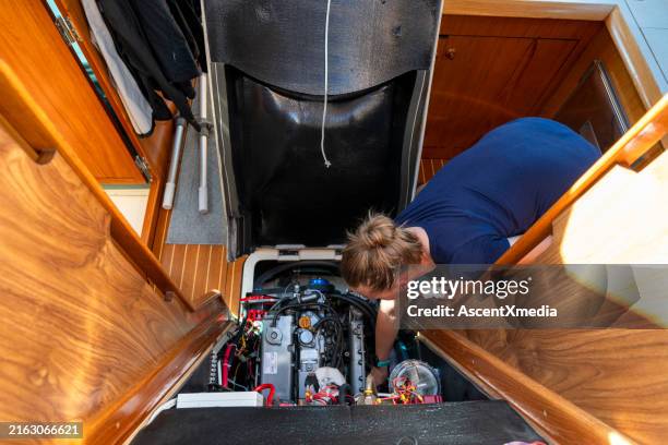 una mujer mantiene el motor de un velero - barco de vela fotografías e imágenes de stock