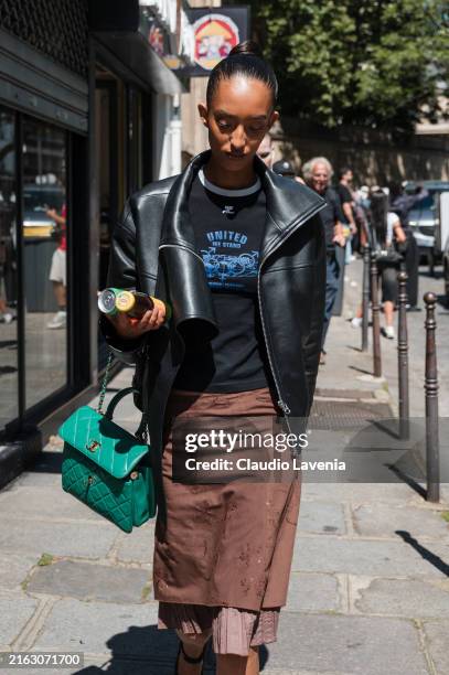 Mona Tougaard wears black printed t-shirt, black leather jacket, brown skirt, green Chanel bag, outside Schiaparelli during the Haute Couture...