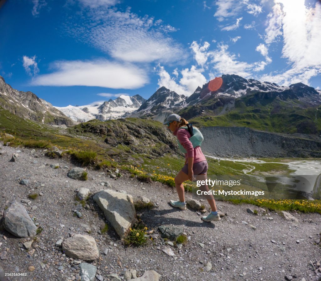 Woman Trekking on Rocky Mountain Trail with Stunning Views