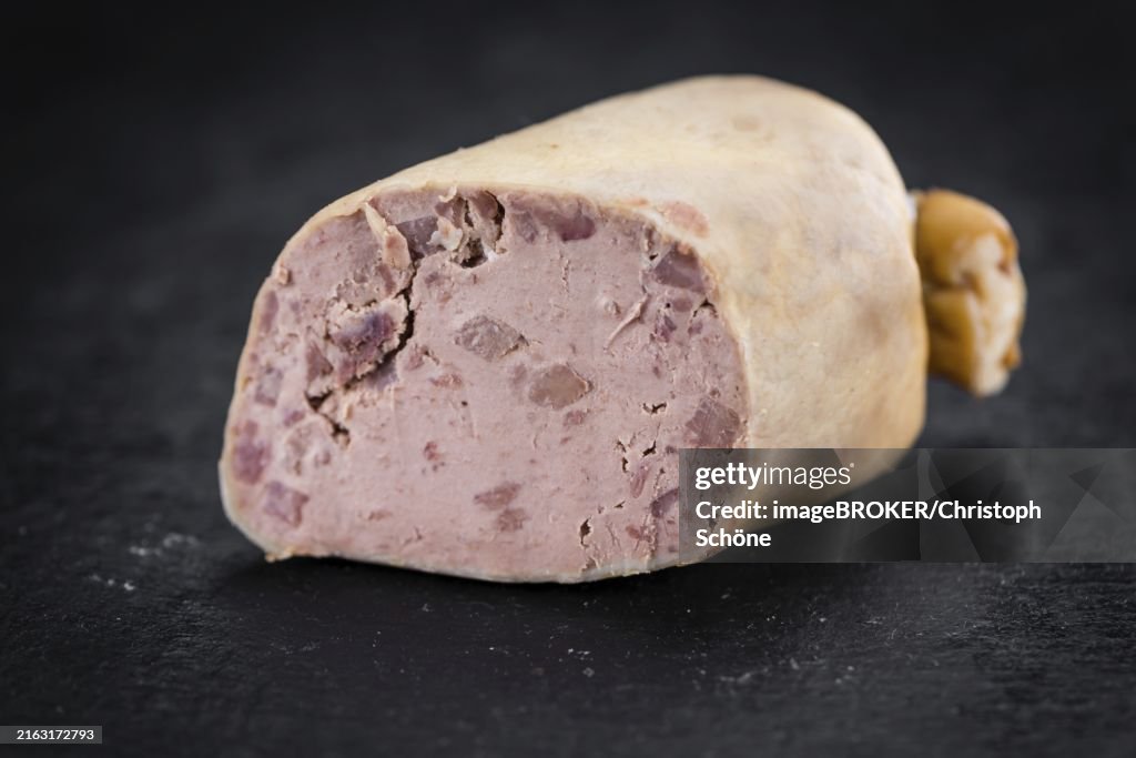 Portion of German Leberwurst as detailed close up shot on a slate slab (selective focus)