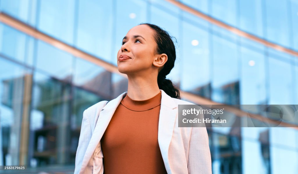 Confident Businesswoman Standing Outdoors with Modern Glass Building Background