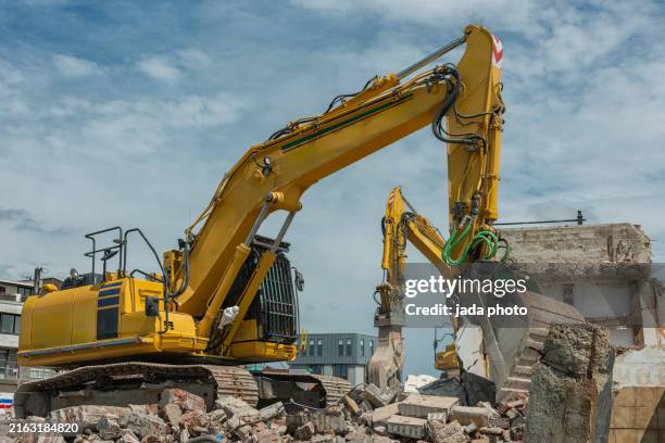 two yellow demolition machines on steel tracks - demolishing stock pictures, royalty-free photos & images