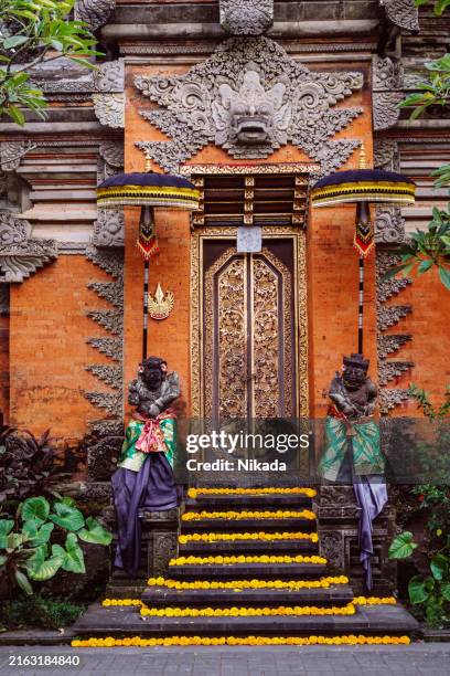 traditional balinese temple entrance with decorative statues and carvings - indonesische cultuur stockfoto's en -beelden