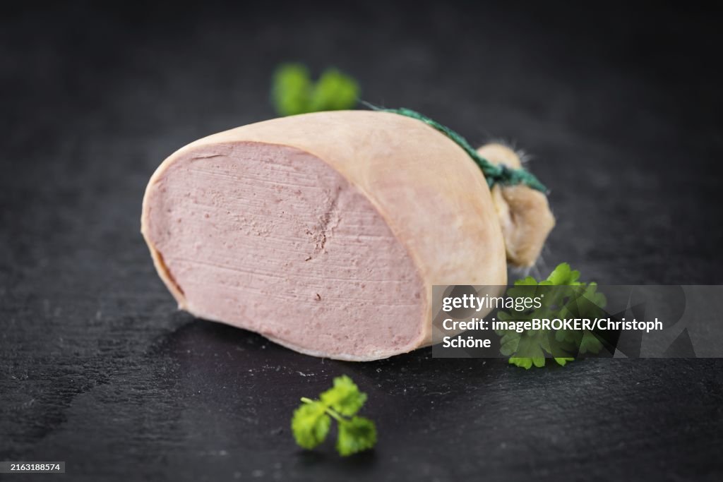 Portion of German Leberwurst as detailed close up shot on a slate slab (selective focus)