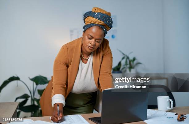 donna nera, budget e scrittura con laptop in ufficio con statistiche per la pianificazione, la ricerca e il rapporto. finanzia, rivedi e pianifica con i dipendenti e i documenti per feedback, analisi o scartoffie sul lavoro - conformità foto e immagini stock