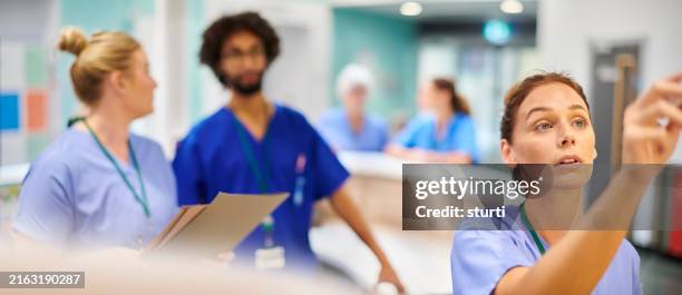 updating ward notes in nursing station - nurses station stock pictures, royalty-free photos & images
