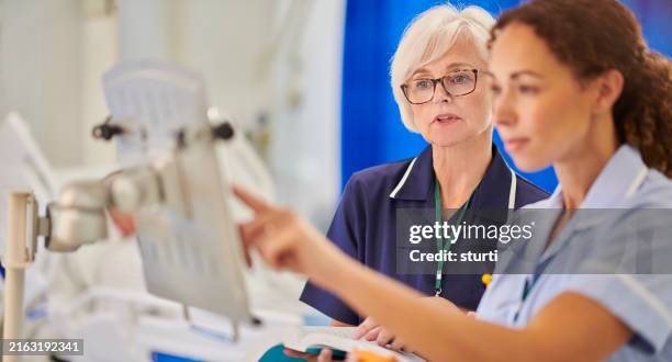 senior staff nurse supervising medicine dosages - nurse stock pictures, royalty-free photos & images