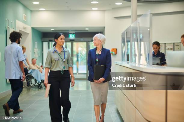 medical sales representative with female doctor - medisch vertegenwoordiger stockfoto's en -beelden