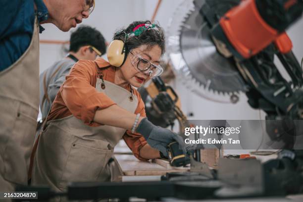 carpintero asiático que imparte clases de carpintería a un estudiante de último año en un taller de carpintería - economía verde fotografías e imágenes de stock