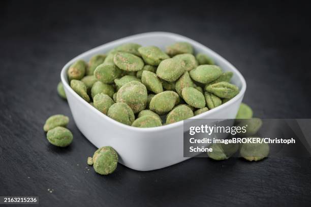 some fresh wasabi peanuts on a vintage slate slab (selective focus, close-up shot) - wasabi stock pictures, royalty-free photos & images