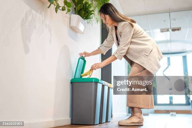 eco-conscious asian businesswoman recycling - vuilnisbak stockfoto's en -beelden