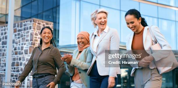 diverse group of businesswomen laughing and walking outside modern office building - happy colleagues doing team building activity imagens e fotografias de stock