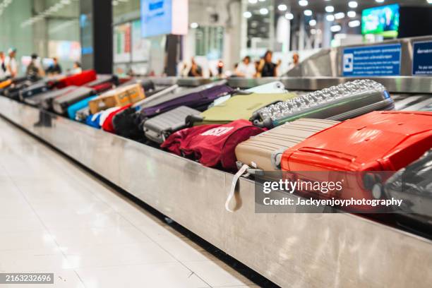 baggages at the airport on a conveyor belt - área de retirada de bagagem - fotografias e filmes do acervo