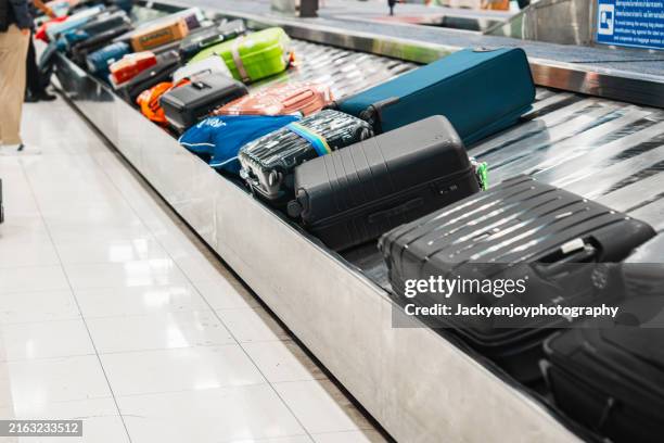 in the international airport, a conveyor belt is used to move luggage or cases. - área de retirada de bagagem - fotografias e filmes do acervo