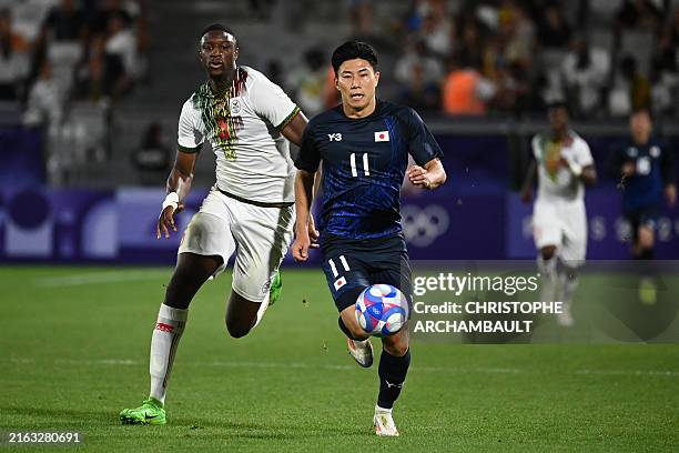 Japan's forward Mao Hosoya and Mali's defender Ibrahima Cisse fight for the ball during the men's group D football match between Japan and Mali...