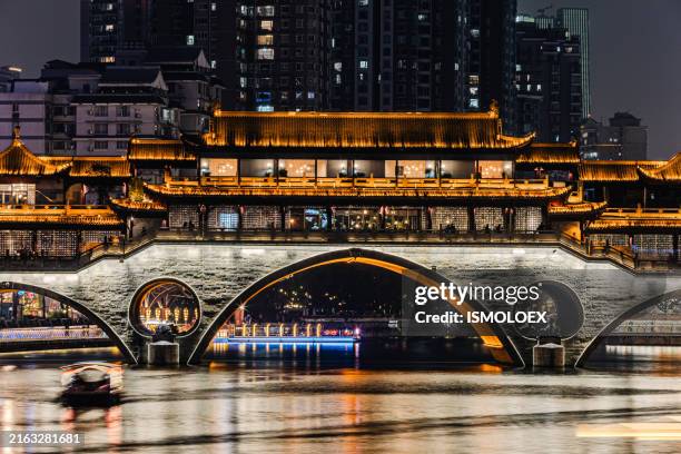 illuminated chinese bridge over a river at night - chengdu stock pictures, royalty-free photos & images