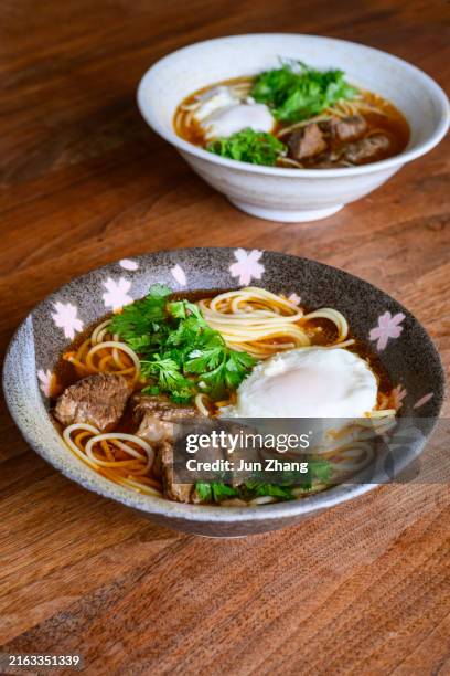 asian food - ramen noodles with meat and poached eggs - koriander stock-fotos und bilder