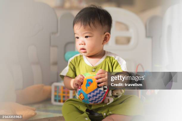 asian family concept little baby boy playing on the foam mat floor with toy block in crib.asian family child stay home lifestlye - gender neutral stock pictures, royalty-free photos & images