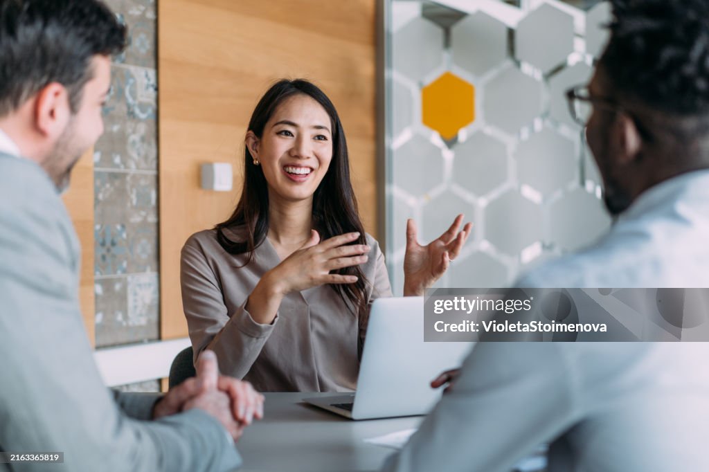 Gruppe von Geschäftsleuten, die im Büro sprechen.