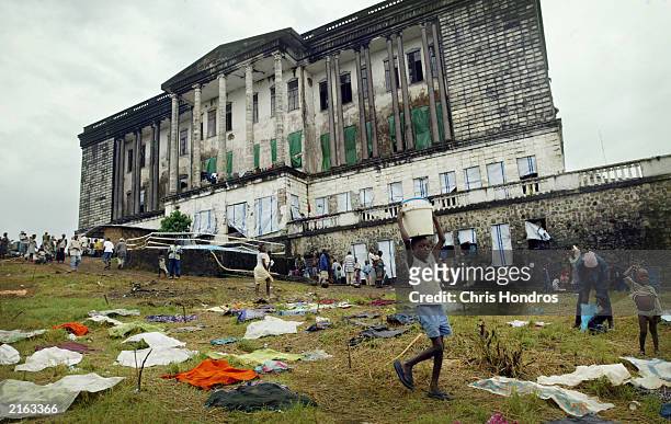 Refugee girl walks admidst laundry scattered around the lawn of a Masonic temple converted into a refugee camp July 15, 2003 in Monrovia, Liberia....