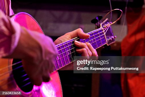Man playing an acoustic guitar on stage Man playing an acoustic guitar on stage
