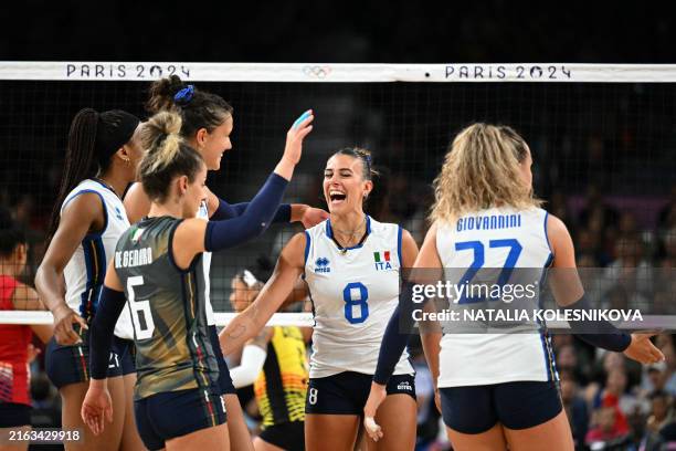 Italy's Monica de Gennaro, Italy's Alessia Orro and Italy's Gaia Giovannini and team mates celebrate winning the women's preliminary round volleyball...