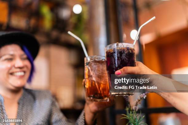 nahaufnahme von freunden, die im restaurant auf getränke anstoßen - soda stock-fotos und bilder