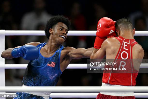 Roscoe Hill punches Refugee Olympic Team's Omid Ahmadisafa in the men's 51kg preliminaries round of 32 boxing match during the Paris 2024 Olympic...