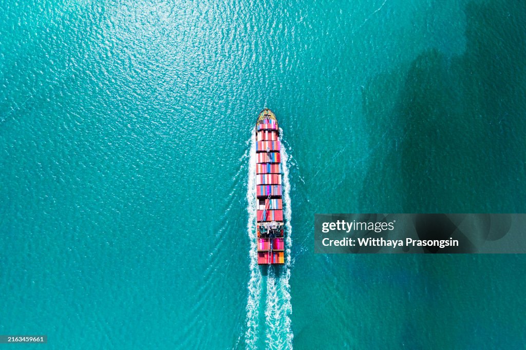 Aerial top view container ship in export and import business and logistics. Shipping cargo to harbor by crane
