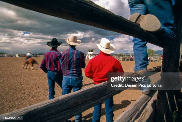 Cowboys watch a rodeo in Nebraska, USA; Mullen, Nebraska, United States of America.