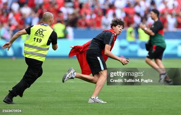 Pitch invader is chased by a steward during the Men's group B match between Argentina and Morocco during the Olympic Games Paris 2024 at Stade...