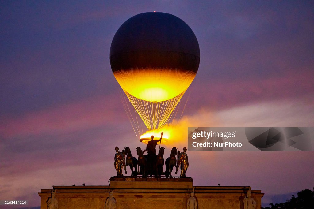 The Cauldron With The Olympic Flame Lit Flies Seen From The Louvre