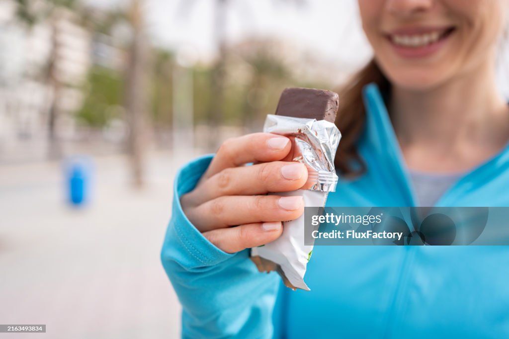 A post-workout treat young girl eats a protein bar