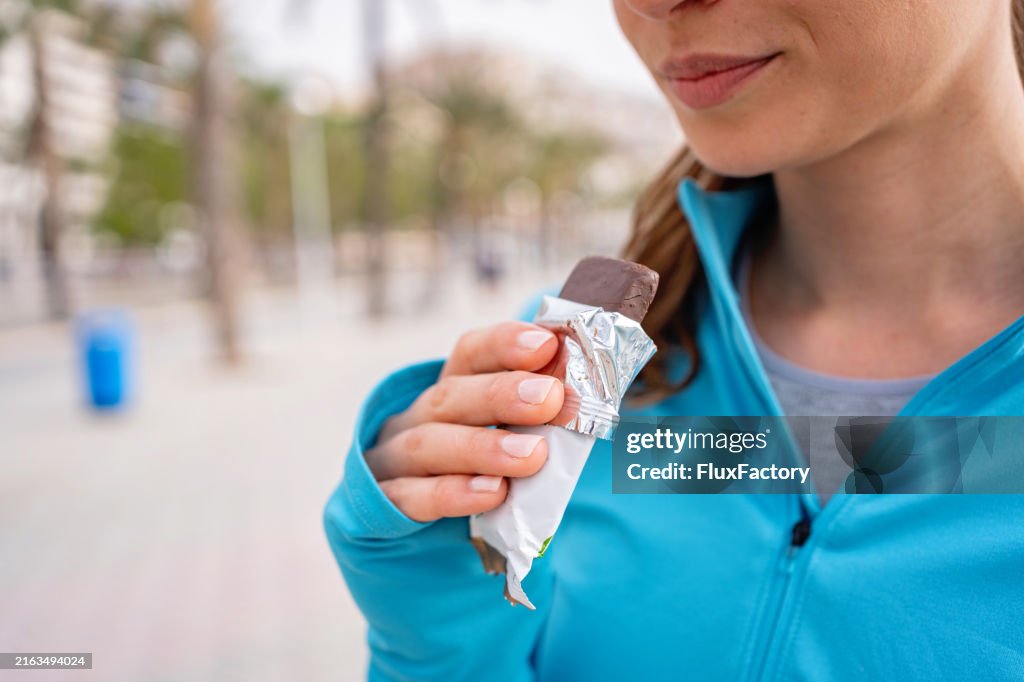 A post-workout treat young girl eats a protein bar